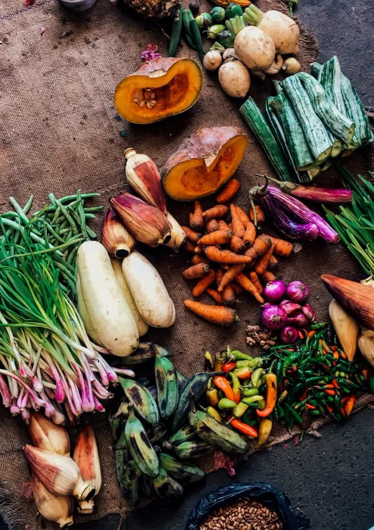 Verduras de estación desplegadas sobre arpillera en un puesto de mercado